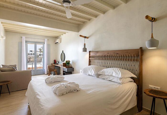 Poseidon Hotel Suites, Mykonos. Gay honeymoon suite with king bed, bathrobes, desk, and balcony. Most-booked hotel in Mykonos Town Chora.