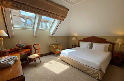 NH Collection Carlo IV, Prague: Luxurious room with a king-size bed, desk, and skylight. Ideal for a gay honeymoon in Prague Old Town.