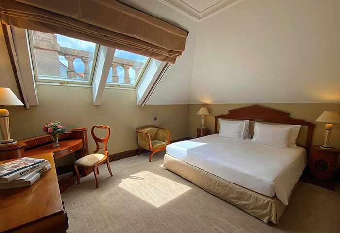 NH Collection Carlo IV, Prague: Luxurious room with a king-size bed, desk, and skylight. Ideal for a gay honeymoon in Prague Old Town.
