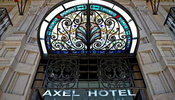 Axel Hotel Barcelona entrance. Gay adults-only urban spa hotel. Ornate stained glass above the door. Top-booked gay hotel in Barcelona.