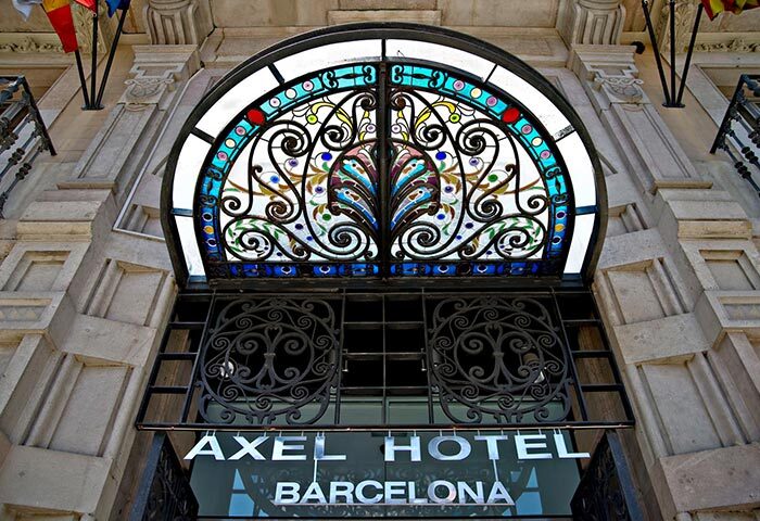 Axel Hotel Barcelona entrance. Gay adults-only urban spa hotel. Ornate stained glass above the door. Top-booked gay hotel in Barcelona.