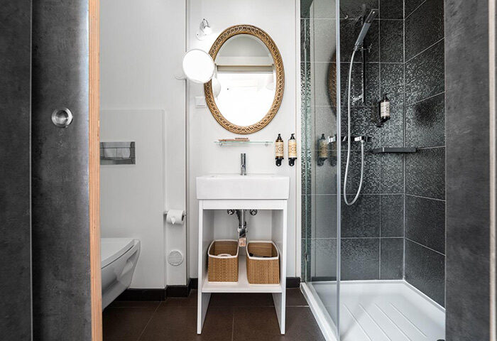 Monte Belvedere Hotel by Shiadu bathroom. Modern design with shower, sink, mirror, & toilet. Most booked gay hotel Lisbon city center.