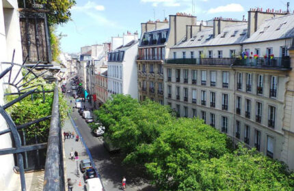 Balcony view from Duo Hotel, a most-booked gay hotel in Paris. The street below is lined with trees and classic Parisian architecture.