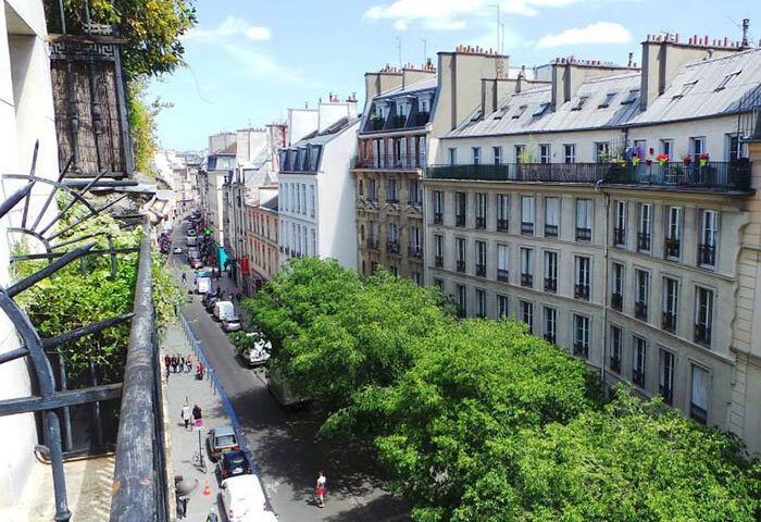 Balcony view from Duo Hotel, a most-booked gay hotel in Paris. The street below is lined with trees and classic Parisian architecture.