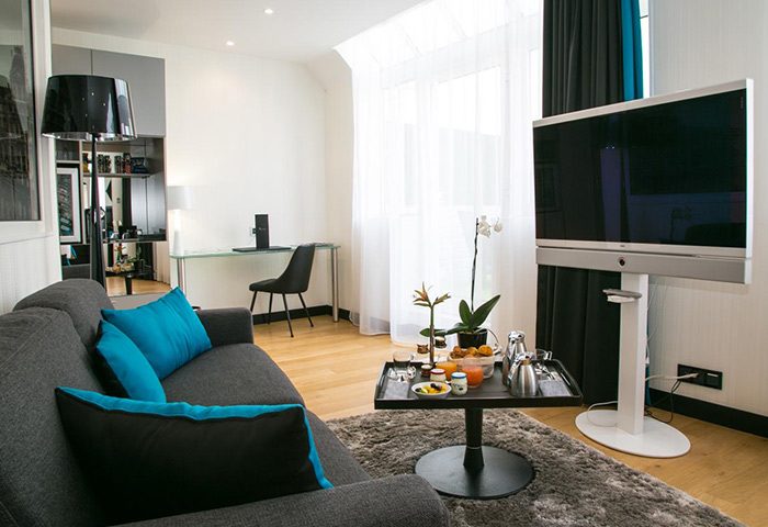 L'Empire Paris Hotel living room. Gay-friendly Paris hotel with modern decor, sofa, & TV. Most-booked hotel for gay travelers in Paris.