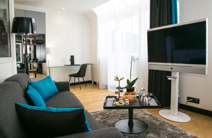 L'Empire Paris Hotel living room. Gay-friendly Paris hotel with modern decor, sofa, & TV. Most-booked hotel for gay travelers in Paris.