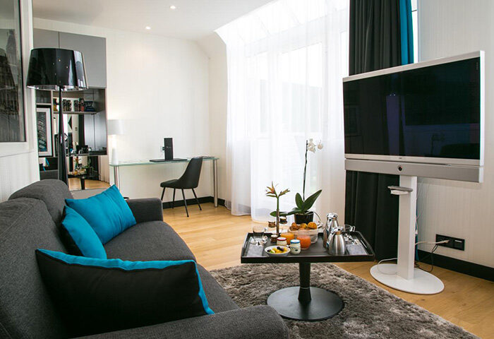 L'Empire Paris Hotel living room. Gay-friendly Paris hotel with modern decor, sofa, & TV. Most-booked hotel for gay travelers in Paris.