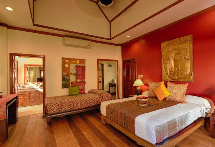 Rabbit Resort Pattaya room. Most booked gay hotel on Dongtan Beach. Thai decor, wooden floors, and red accent wall.