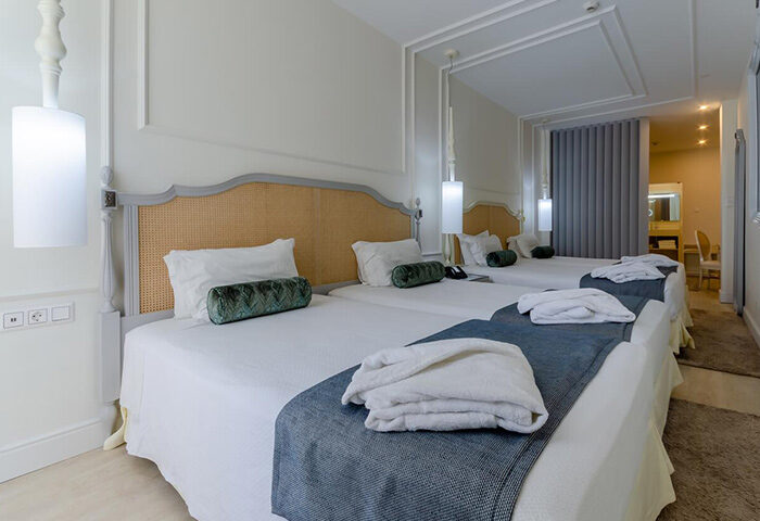 Hotel Borges Chiado room for 4 gay people in Lisbon. Triple beds, bathrobes, & stylish decor. Perfect for gay travelers in Lisbon's gayborhood.