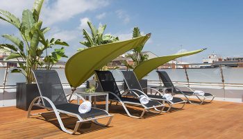 Ako Suites Hotel rooftop terrace with lounge chairs and sunshades. Most-booked gay hotel serviced apartment in Barcelona's gayborhood.