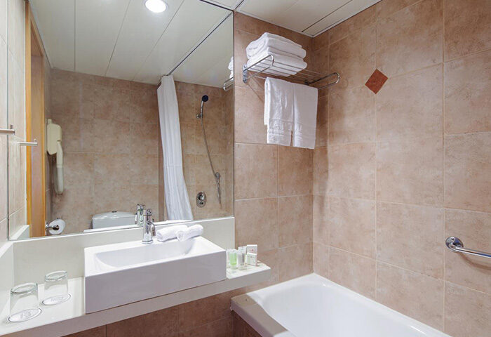 Prima City Hotel Tel Aviv bathroom. Most booked gay hotel by the beach. Sink, mirror, shower, towels. Ideal for 3 people group.