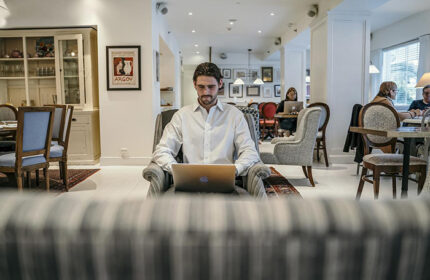 Shalom Hotel & Relax, Atlas Boutique Hotel: Man works on laptop in lobby. Gay hotel in Tel Aviv for meeting other gay travelers.