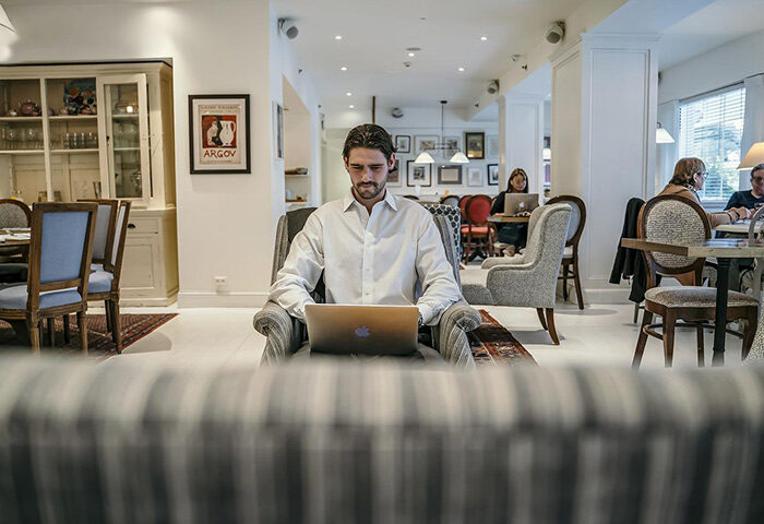 Shalom Hotel & Relax, Atlas Boutique Hotel: Man works on laptop in lobby. Gay hotel in Tel Aviv for meeting other gay travelers.