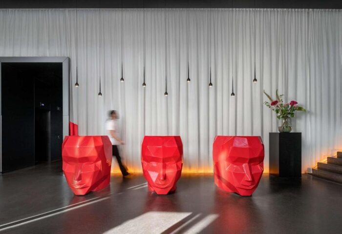 Art'otel Amsterdam lobby. Red geometric face sculptures serve as reception desks. Modern, stylish design for gay travelers in Amsterdam.