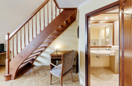 Louren Hotel, Prague. Interior view of a room at this most-booked gay hotel in Vinohrady, for gay groups. Wooden staircase and bathroom.