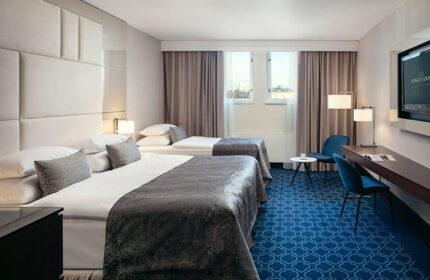 Hotel Kings Court, Prague: Luxury room for three persons in Old Town. Most booked gay hotel with two beds, blue carpet, desk, and chairs.