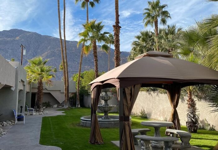 All Worlds Resorts and Annex, a gay men's resort in Palm Springs. Lush grounds with gazebo, fountain, and mountain views. Clothing optional.