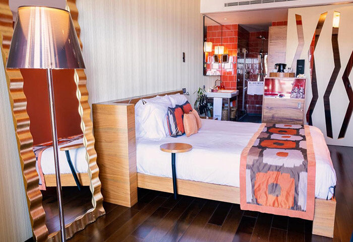 Bohemia Suites & Spa Adults Only hotel room in Playa del Ingles, Gran Canaria. Luxury gay hotel with bed, mirror, and open bathroom.