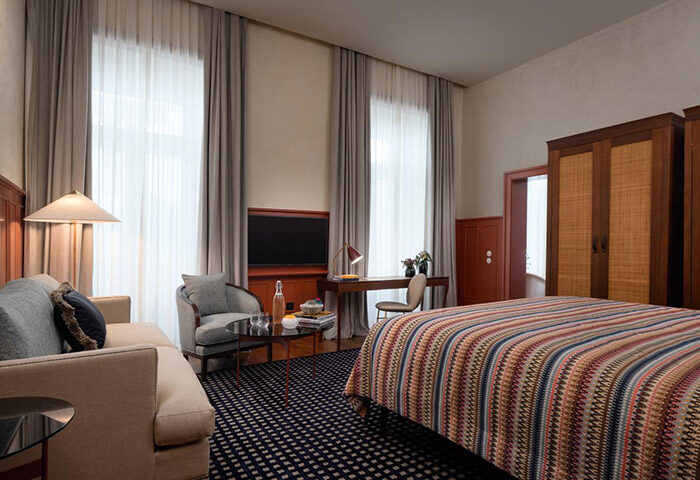 Bairro Alto Hotel, Lisbon. Luxury room interior at this most-booked gay hotel. Features a bed, desk, seating area, and modern decor.