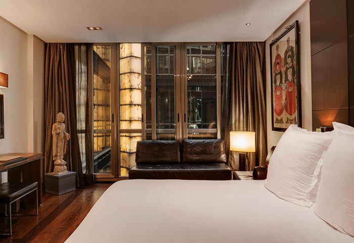 Urban Hotel, most booked luxury gay hotel in Madrid's Chueca gayborhood. Room with double bed, sofa, and city view.