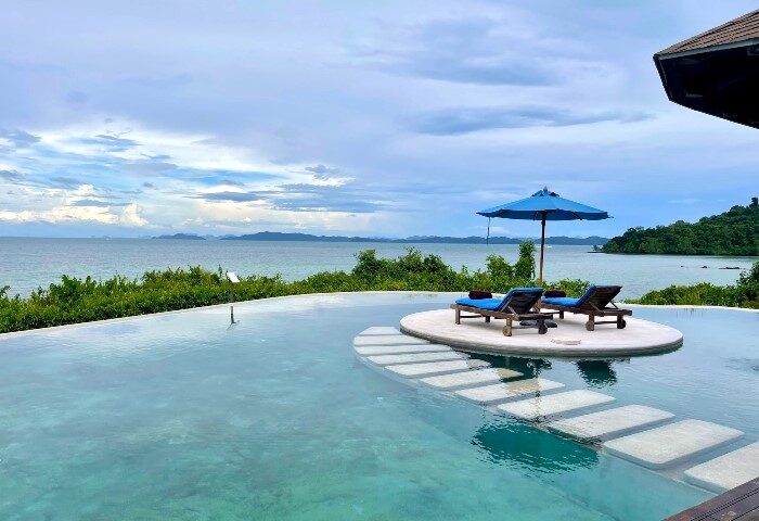 The Naka Island, a Luxury Collection Resort & Spa, Phuket. Infinity pool with ocean view, lounge chairs, umbrella. Most booked gay hotel.