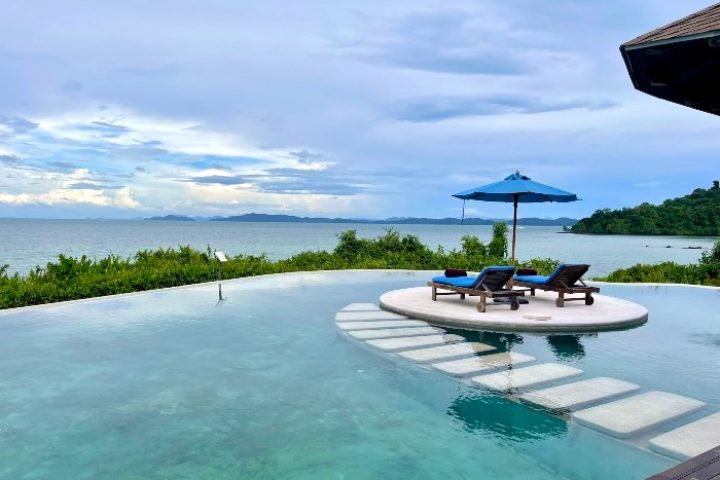 The Naka Island, a Luxury Collection Resort & Spa, Phuket. Infinity pool with ocean view, lounge chairs, umbrella. Most booked gay hotel.