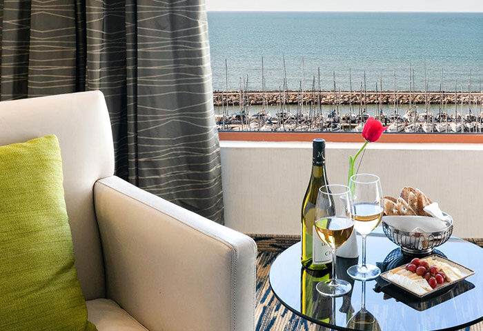 Luxury Carlton Tel Aviv Hotel room with wine, cheese, and ocean view. Most-booked gay hotel near Hilton Beachfront with rooftop pool.