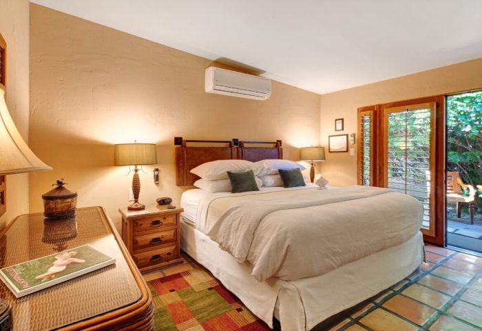 Bedroom at The Hacienda, a luxury gay resort in Palm Springs. King bed, desert decor, and patio access. Perfect for gay men's travel.