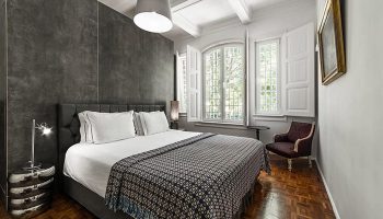 Monte Belvedere Hotel by Shiadu room. Lisbon gayborhood party hotel with bed, windows, chair, and wood floors. Gay travel.
