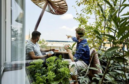 Gay couple at Mosaic House Design Hotel in Prague's Old Town. Men enjoy city views from the hotel terrace with drinks, perfect for gay travel.