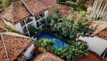 Rambutan Resort Siem Reap aerial view. Charming gay hotel with pool, lush greenery, red tile roofs. Ideal for gay men's travel in Cambodia.