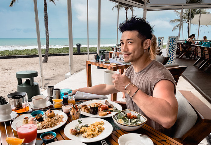 Gay-friendly W Bali Seminyak: Man enjoying breakfast with ocean view. Beachfront dining at one of Bali's best hotels.