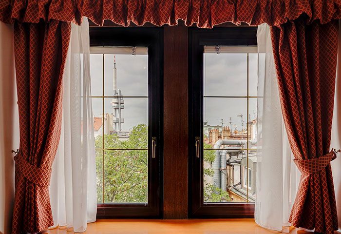 View from Louren Hotel, a popular gay hotel in Prague's gayborhood. Window with red curtains and Zizkov TV Tower in the background.