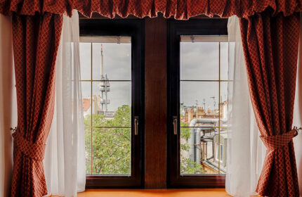 View from Louren Hotel, a popular gay hotel in Prague's gayborhood. Window with red curtains and Zizkov TV Tower in the background.