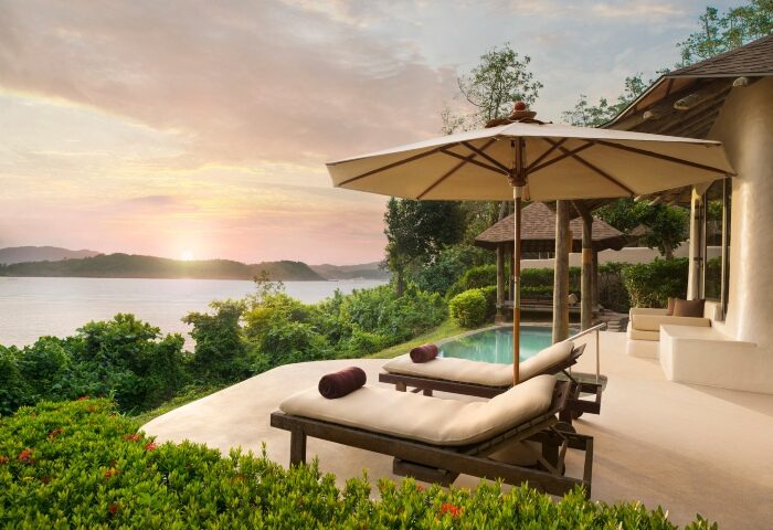 Luxury pool villa at The Naka Island, a Luxury Collection Resort & Spa, Phuket. Gay hotel with ocean view, lounge chairs, and sunset.