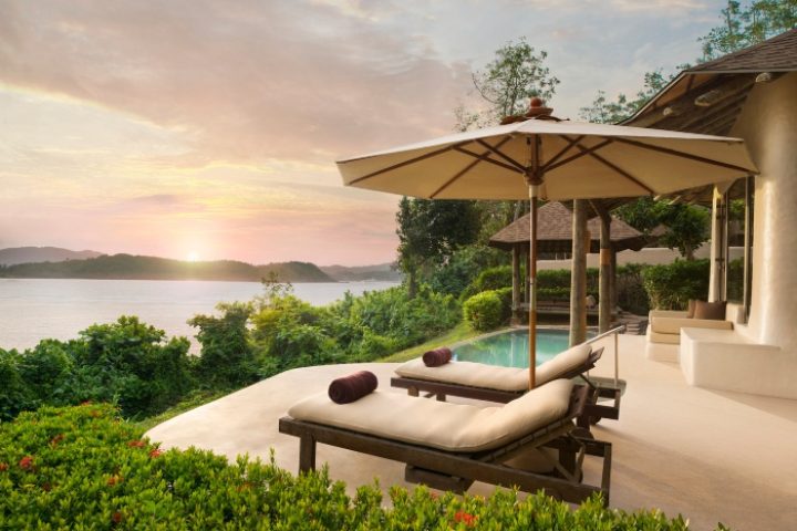 Luxury pool villa at The Naka Island, a Luxury Collection Resort & Spa, Phuket. Gay hotel with ocean view, lounge chairs, and sunset.