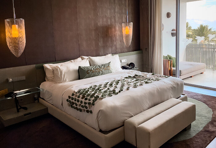 W Bali Seminyak gay hotel room. King bed, balcony, and modern design. Popular gay beach hotel in Bali. Luxury travel destination.