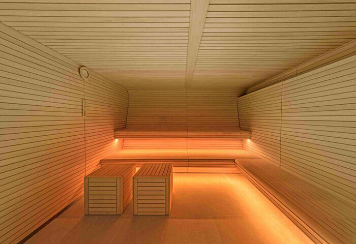 W Barcelona's sauna. A gay-favorite hotel in Barcelona featuring a wooden sauna with benches and ambient lighting for relaxation.