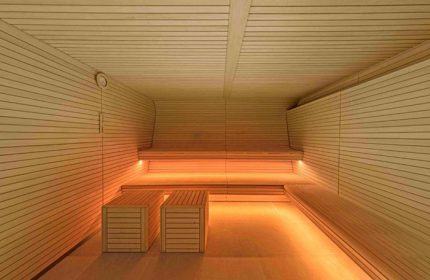 W Barcelona's sauna. A gay-favorite hotel in Barcelona featuring a wooden sauna with benches and ambient lighting for relaxation.