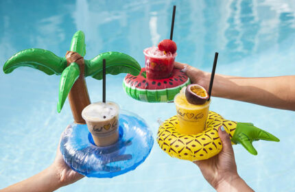 Herods Tel Aviv By The Beach: Drinks with inflatable holders in a pool. Gay couples and friends can enjoy poolside cocktails at this hotel.