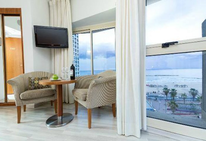 Maxim Design Hotel 3 Star Superior room in Tel Aviv. Beach view, chairs, table with wine. Popular gay hotel near the beach.