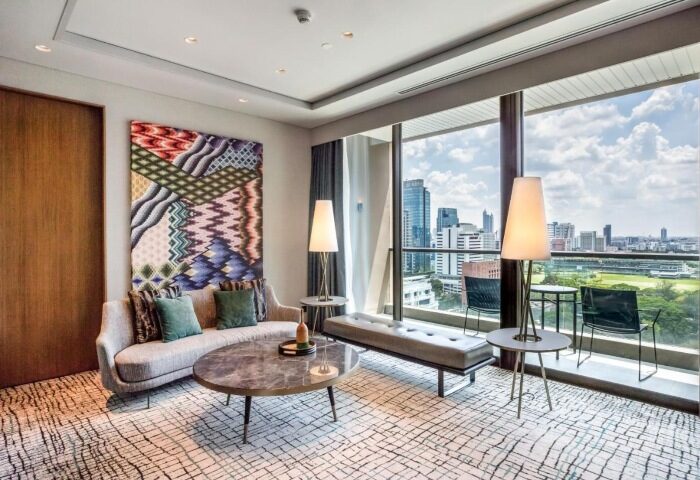 Kimpton Maa-Lai Bangkok city center suite. Stylish room at a popular gay hotel, with skyline views, sofa, and modern decor.