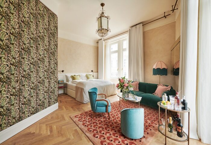 Hotel Motto, a popular gay hotel in Vienna. Stylish room with bed, sofa, and bar cart. Perfect for gay travelers seeking luxury.