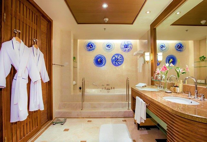 Shangri-La Chiang Mai luxury hotel bathroom. Honeymoon suite with robes, jacuzzi, and marble vanity. Gay travel.