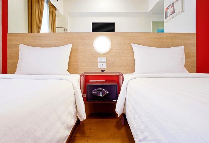 Red Planet Manila Makati hotel room with twin beds. Safe box between beds. Popular hotel for gay couples. Modern, clean, and comfortable stay.