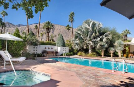 The Hacienda at Warm Sands pool. A luxury gay resort in Palm Springs. Mountains, trees, and lounge chairs visible.