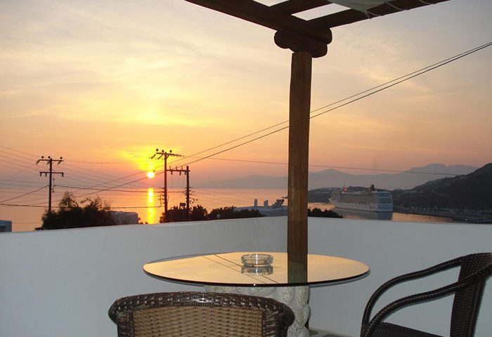 Sahas Suites' self-catering apartment view at sunset. Popular among gay travellers, it offers a scenic balcony with a cruise ship view.