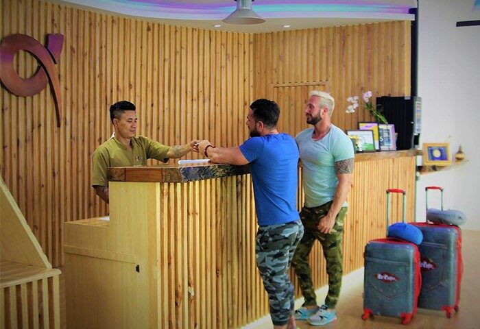Alpha Gay Resort & Spa Koh Samui: Gay men check in at the popular, cheap gay hotel. Reception area with guests and luggage.