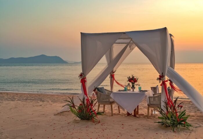 Romantic honeymoon dinner setup at Renaissance Pattaya Resort & Spa. Gay-friendly hotel with beach view at sunset. Perfect for LGBT travel.