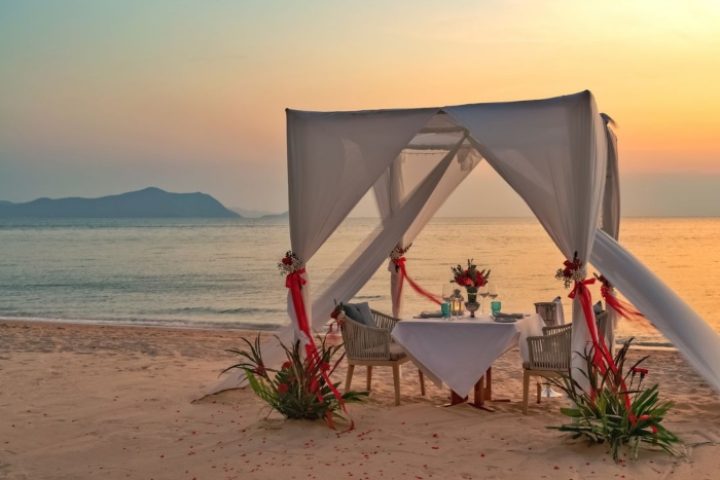 Romantic honeymoon dinner setup at Renaissance Pattaya Resort & Spa. Gay-friendly hotel with beach view at sunset. Perfect for LGBT travel.